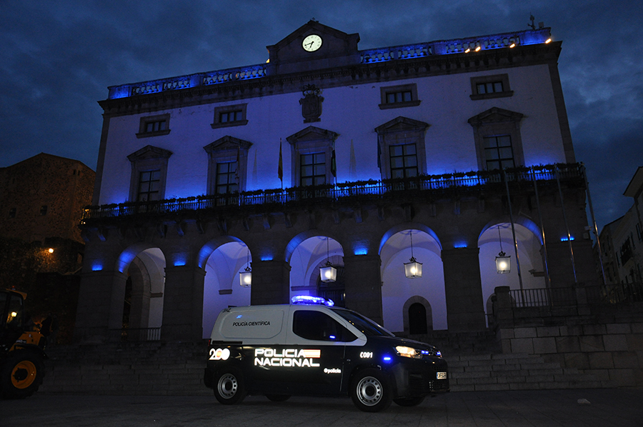 Monumento histórico de Cáceres iluminado con el color azul de la Policía Nacional
